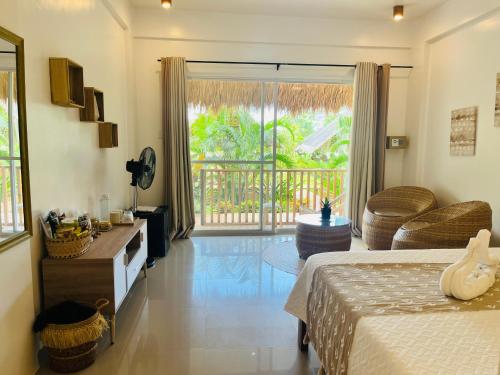 a bedroom with a bed and a view of a balcony at La Palapa Inn Port Barton in San Vicente