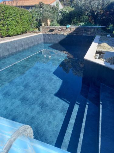 a swimming pool with blue water in a house at Chambres d'hôtes Sous L'Olivier in Trausse