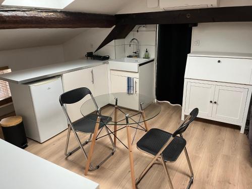 - une cuisine avec 2 chaises, un comptoir et un évier dans l'établissement La Tour Ronde, à Grézieu-la-Varenne