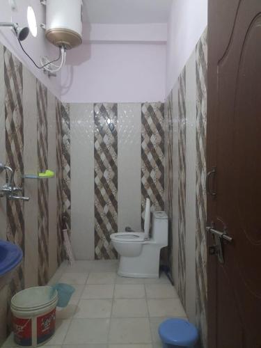 a small bathroom with a toilet in a room at Mangalam Palace in Uttarkāshi