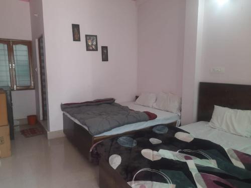 a room with two beds in a room at Mangalam Palace in Uttarkāshi