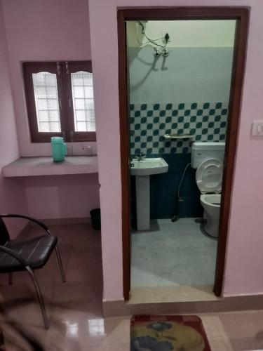 a bathroom with a toilet and a sink at Mangalam Palace in Uttarkāshi