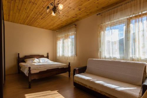 um quarto com uma cama, um sofá e uma janela em Apartment Sjekloca em Virpazar