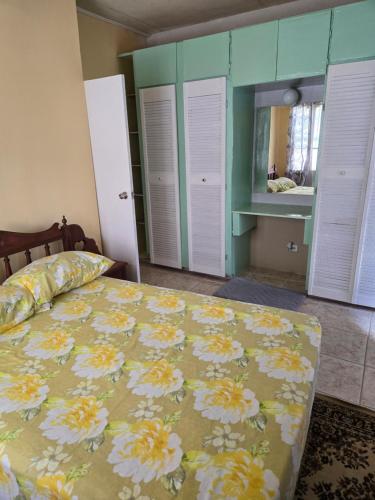 een slaapkamer met een bed met een bloemenbed en een spiegel bij Bagatelle Terrace in Saint James