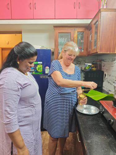 two women standing in a kitchen preparing food at Oyster Marris Homestays in Trivandrum