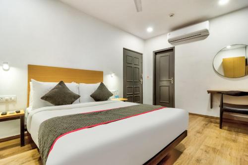 a bedroom with a bed and a desk and a mirror at Hotel O Akash Ganga Park Circus in Ballygunge