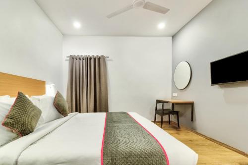 a bedroom with a bed and a flat screen tv at Hotel O Akash Ganga Park Circus in Ballygunge