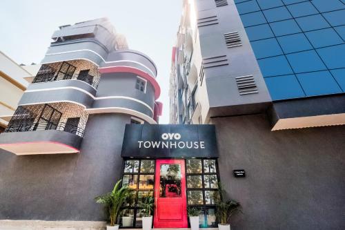 a front view of a town house with a red door at Hotel O Akash Ganga Park Circus in Ballygunge