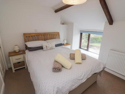 a bedroom with a large bed with pillows and a window at Florida Cottage in Swansea