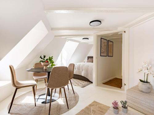 a dining room with a table and chairs and a bedroom at Sanders Admiral - Cosy 1-Bdr Apt in Copenhagen