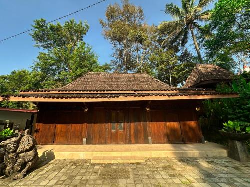 a house with a wooden door in a yard at Puunee Wild River Villa's Borobudur in Borobudur