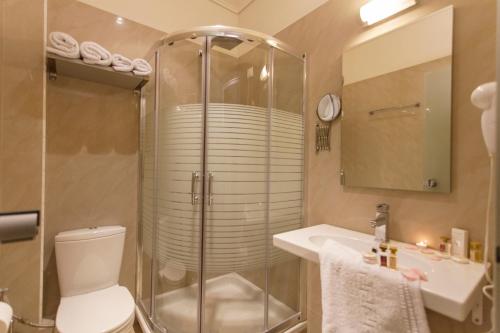 y baño con ducha, aseo y lavamanos. en Hotel Aheron, en Kanallákion