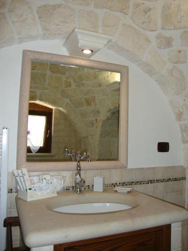 a bathroom with a sink and a mirror at Trulli IsAgo in Locorotondo