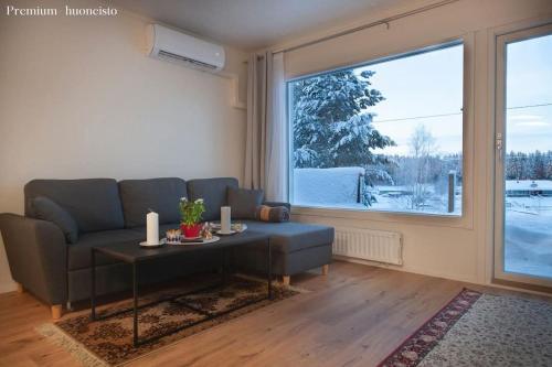 a living room with a couch and a table and a window at Saimaan Kodikas Premium in Savonlinna