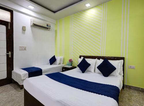 two beds in a room with green and white at Hotel Nancy Dx Near New Delhi Railway Station in New Delhi