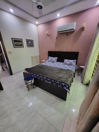 a bedroom with a large bed in a pink wall at The Home Sweet Home in Karachi