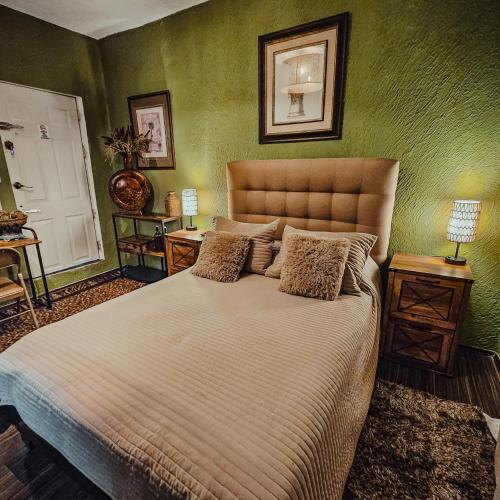 a bedroom with a large bed with green walls at Habitación con baño privado A, Centro de Coyoacán in Mexico City