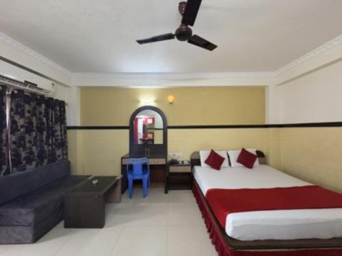 a bedroom with a bed and a desk and a ceiling fan at Hotel Inn New Digha With Classic Swimming Pool in Digha