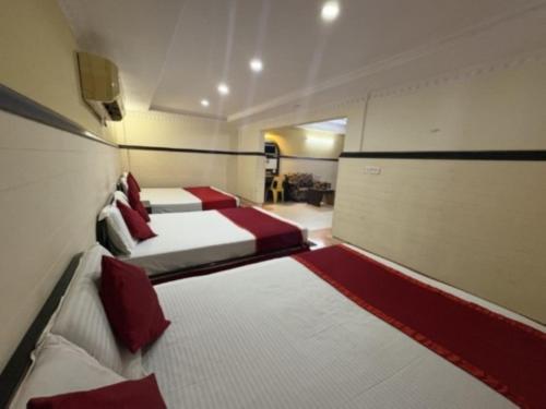 a room with two beds with red pillows at Hotel Inn New Digha With Classic Swimming Pool in Digha