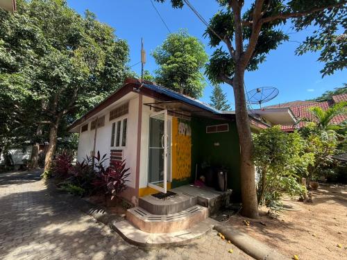 a small white and green house with a tree at Sawasdee House in Lamai