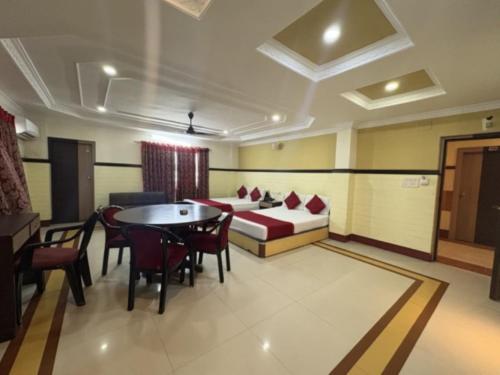 a bedroom with a bed and a table and chairs at Hotel Inn New Digha With Classic Swimming Pool in Digha