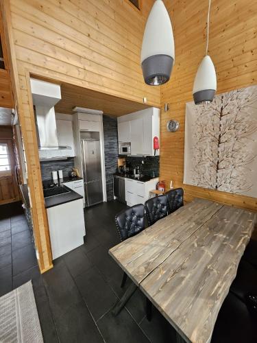 a kitchen and dining room with a wooden table at Levi Happi in Kittilä