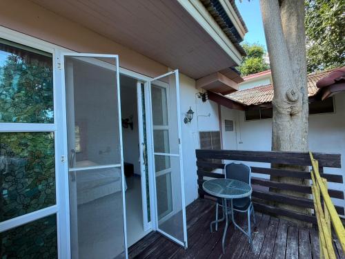 a balcony with a table and a glass door at Sawasdee House in Lamai