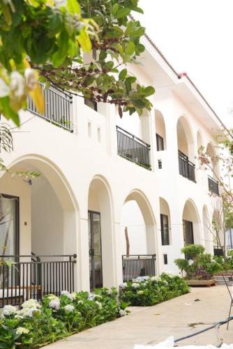 a white building with balconies on the side of it at An Home - Garden Homestay in Plei Brel (2)