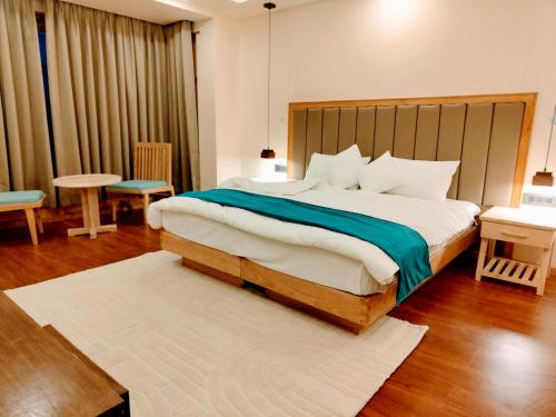 a bedroom with a large bed with a wooden headboard at The Rangjung Hotel in Leh