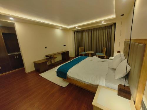 a hotel room with a large bed and a desk at The Rangjung Hotel in Leh