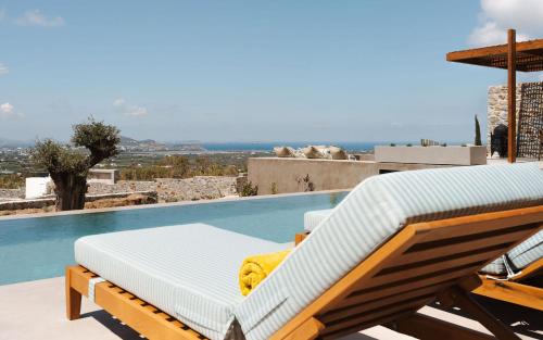 a bed sitting next to a swimming pool at Theros Villas Naxos in Plaka