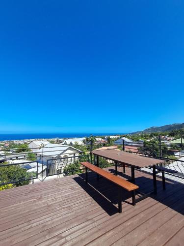 a wooden deck with a picnic table and the ocean at l'Antre-Temps, maison atypique in Saint-Joseph