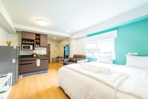 a large bedroom with a large bed and a kitchen at GL Sport Club Serviced Residence in Bangkok