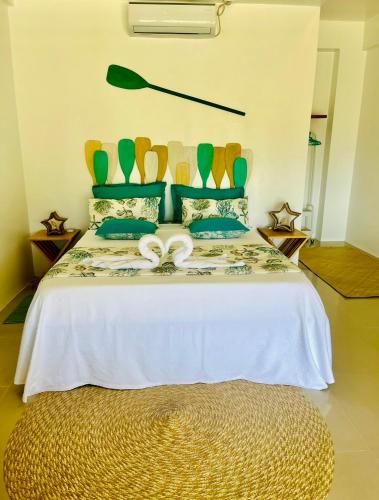 a bedroom with a bed with two white bows on it at La Palapa Inn Port Barton in San Vicente
