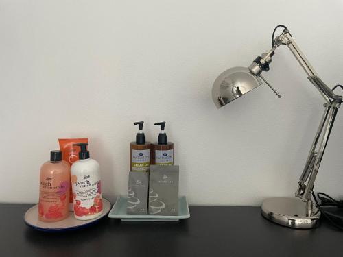 a desk with two bottles of soap and a lamp at INN MY PLACE in Pak Chong