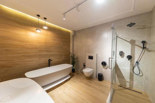 ein Badezimmer mit weißer Badewanne und Dusche in der Unterkunft Apart & Spa Beganovic in Dobra Voda