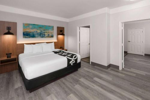 a bedroom with a large bed with white sheets at La Quinta by Wyndham Angleton in Angleton