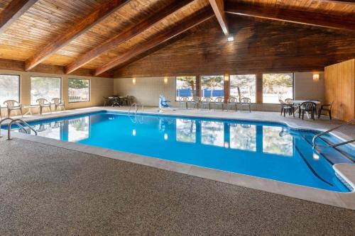 a large swimming pool in a large building with a pool at AmericInn by Wyndham Oscoda Near AuSable River in Oscoda