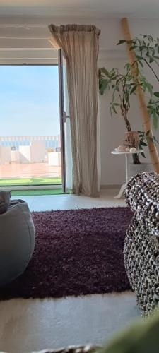 a living room with a purple rug and a large window at Eneide in Palmi