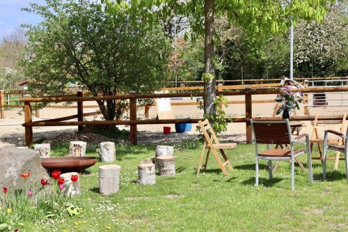 a garden with a table and chairs in the grass at Herzstück vom Ponyhof in Bassum