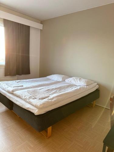 Una cama grande en un dormitorio con ventana. en Hilla room, en Rovaniemi