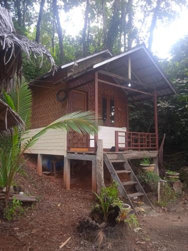 a small house with a porch and stairs to it at batu putih cottage karimunjawa in Karimunjawa