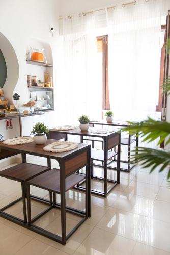 a kitchen with tables and chairs in a room at Camera Ardea in Aversa