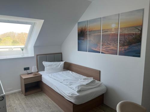 a bedroom with a bed with a picture on the wall at Hotel am Schlosspark Superior in Putbus