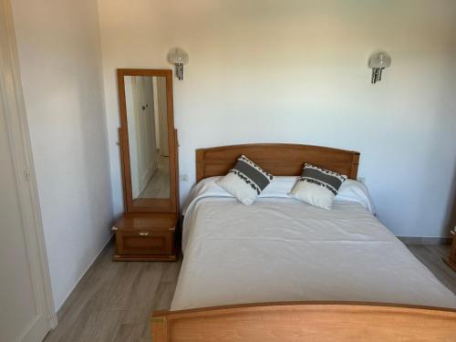 a bedroom with a bed with two pillows and a mirror at SICILIA VILLA in La Ciotat