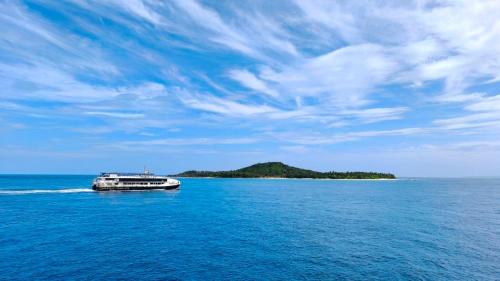 a boat in the ocean with an island in the background at Fernando's Hotel in Sorsogon