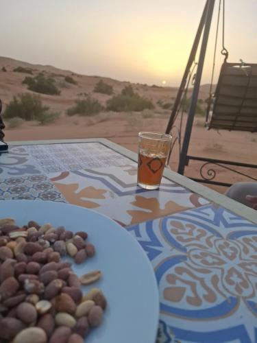 a table with a plate of food and a drink at Morocco Deluxe Camp - Assif n'Itrane in Lac Yasmins