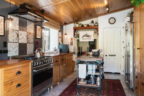 a kitchen with wooden cabinets and a stove at Carrowmore House in Naseby