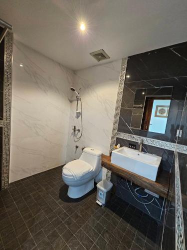 a bathroom with a toilet and a sink at Madugu Service Apartment in Chiang Mai
