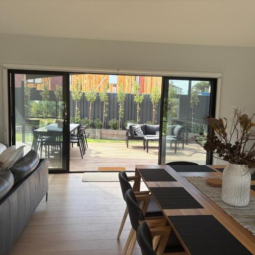 a living room with a table and chairs at Goolwa Beach Pavilion in Goolwa South